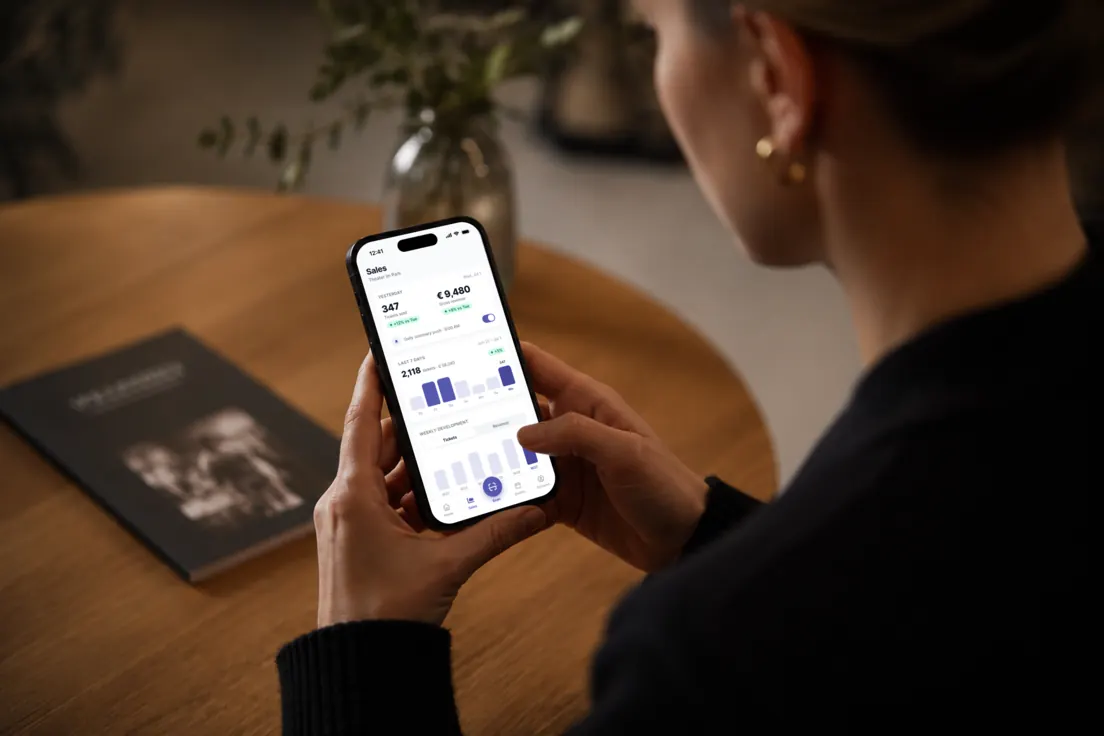 An organiser checking the live figures on her phone at a table