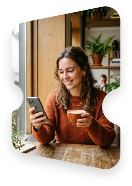 A guest smiling at their phone over coffee, masked into the Entrello ticket mark